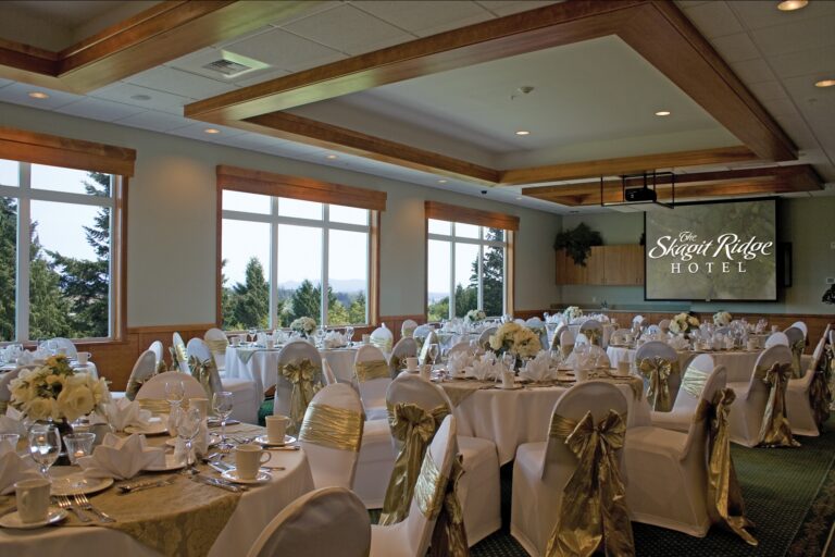 The Summit Room at The Skagit Ridge Hotel, set with round tables beneath large windows