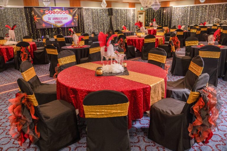 A banquet table dressed in red and gold with a centrepiece