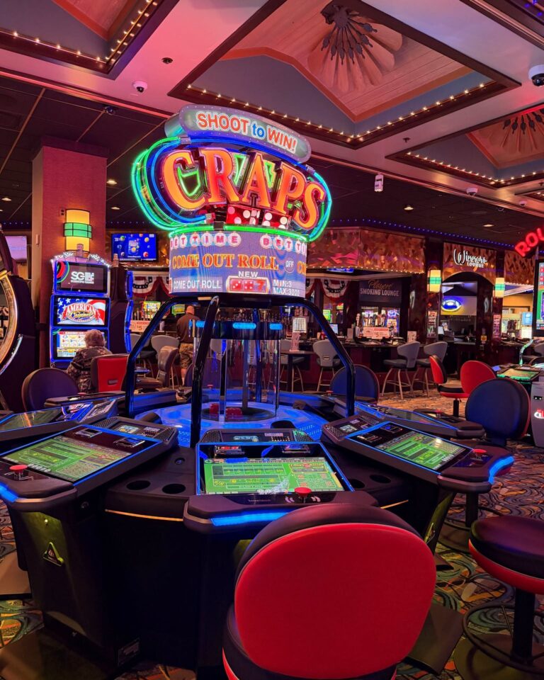 The Shoot to Win electronic craps table on the casino floor, with individual player terminals around a lit dice dome