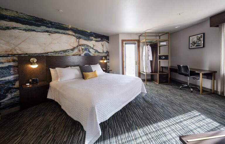 Panoramic view of the King Suite showing the bed, the seating area and the window in one sweep