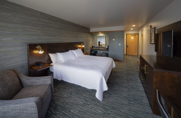 Panoramic view of a Single King room showing the bed, desk and window together